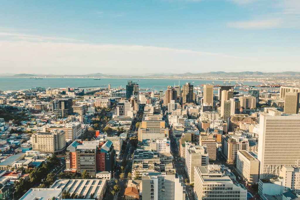Stunning aerial view of Cape Town cityscape with its skyline and ocean in the background on a bright day.